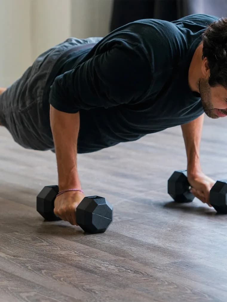 Trening siłowy z hantlami w jasnym pomieszczeniu